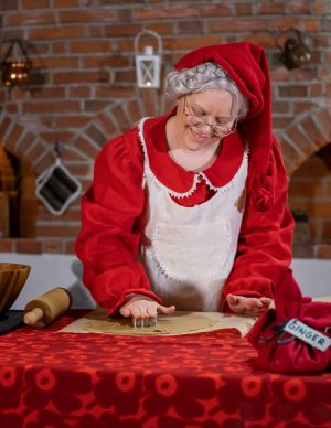 Mrs. Santa Claus preparing gingerbread in her Christmas Cottage in Rovaniemi